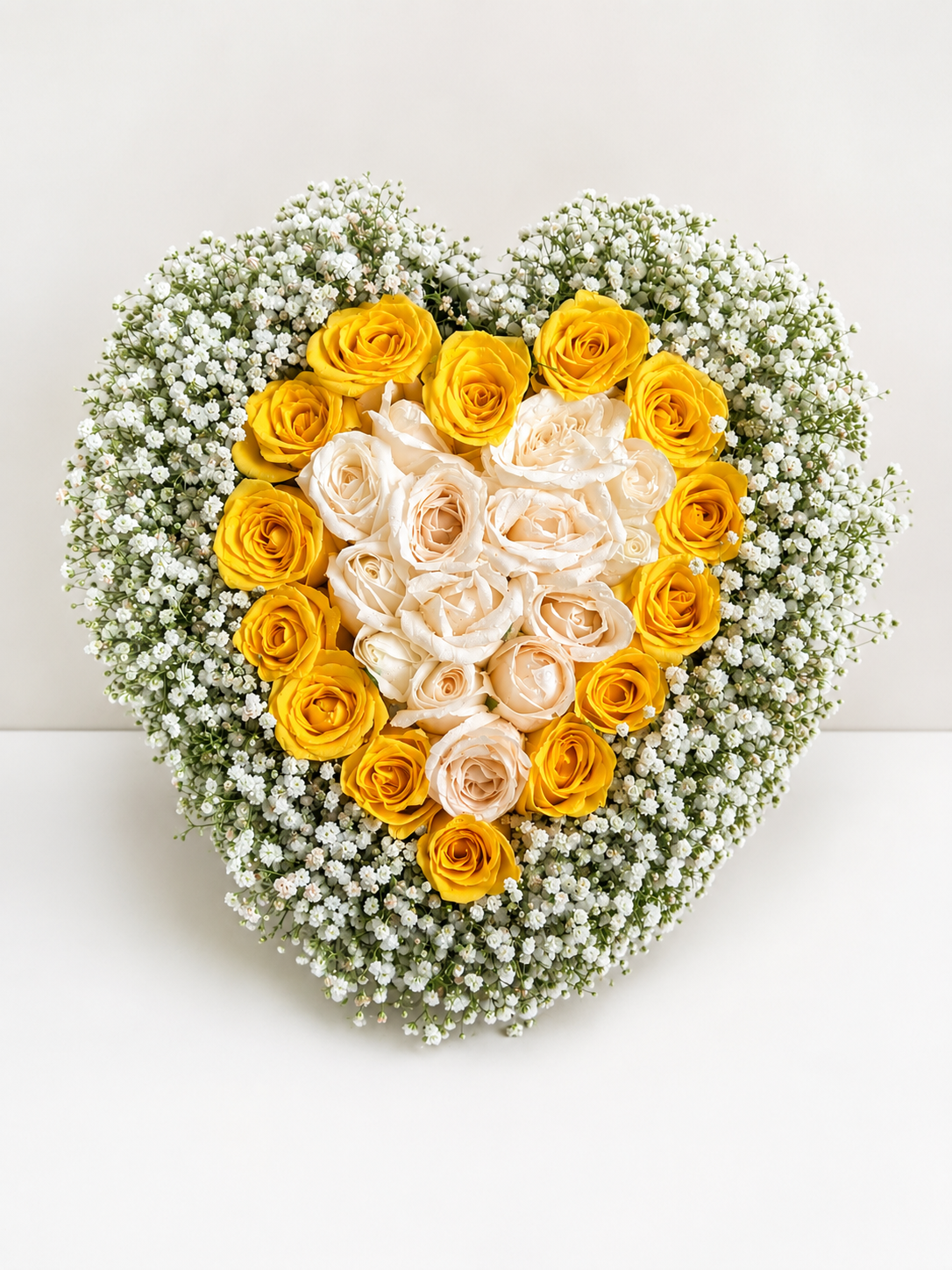 Golden Heart Rose Arrangement featuring premium yellow roses, white roses and baby's breath in a handcrafted heart-shaped floral design.